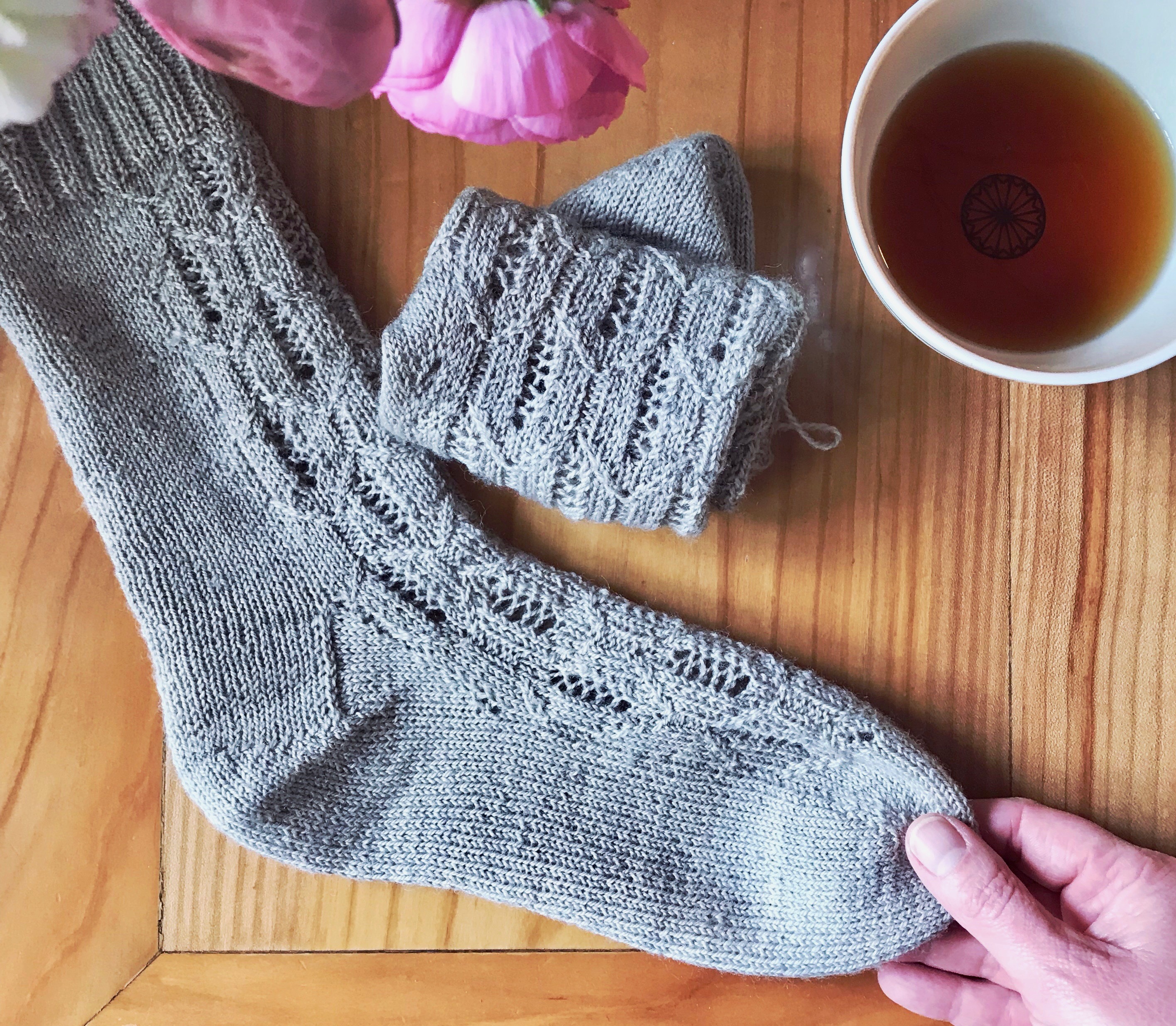 Flatlay of Morningside socks with a cup of tea and roses.
