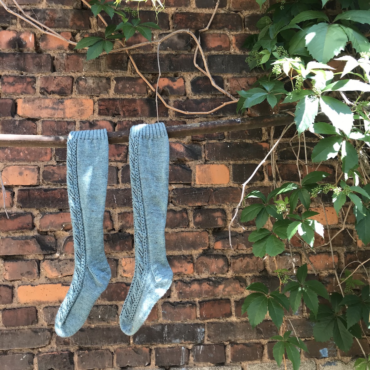 Knitted knee high socks in front of a brick wall